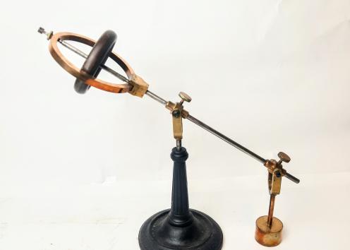 A gyroscope on an arm with an attached weight on the other end of the arm.