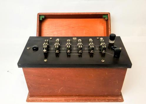 This Leeds & Northrup Adjustable Mica Capacitor model 1058 has capacitance of 1 microfarad in five sections of 0..5,0.2,0.2,0.05 and 0.05 microfards. It has knife switch connections in various series and multiple combinations. It comes in a mahogany case with a cover. 