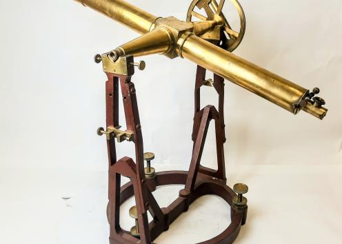 This is a transit, a type of telescope with a built-in spirit level and extremely fine calibration screws to allow its user to level the device exactly and thus take very precise measurements of the positions of celestial bodies. Brass telescope placed on a heavy metal mount. 
